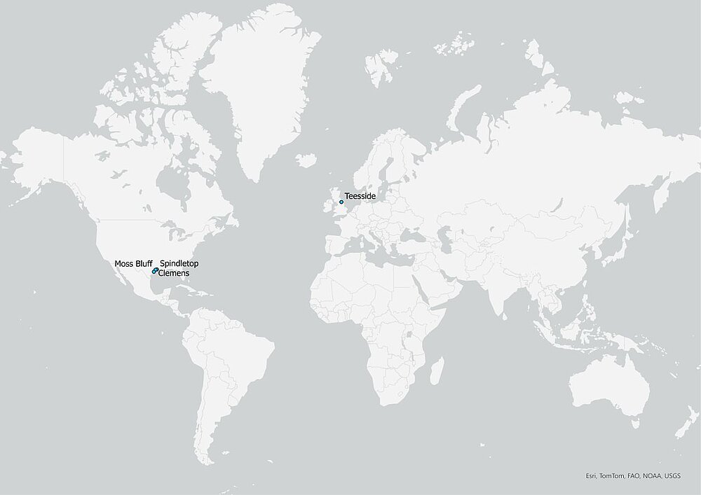 Die Abbildung zeigt eine Weltkarte mit weißen Ländern auf grauem Hintergrund. Es sind die vier oben genannten Lokationen mit einem blauen Punkt eingetragen. Die Namen der Lokationen sind neben Punkten angeordnet